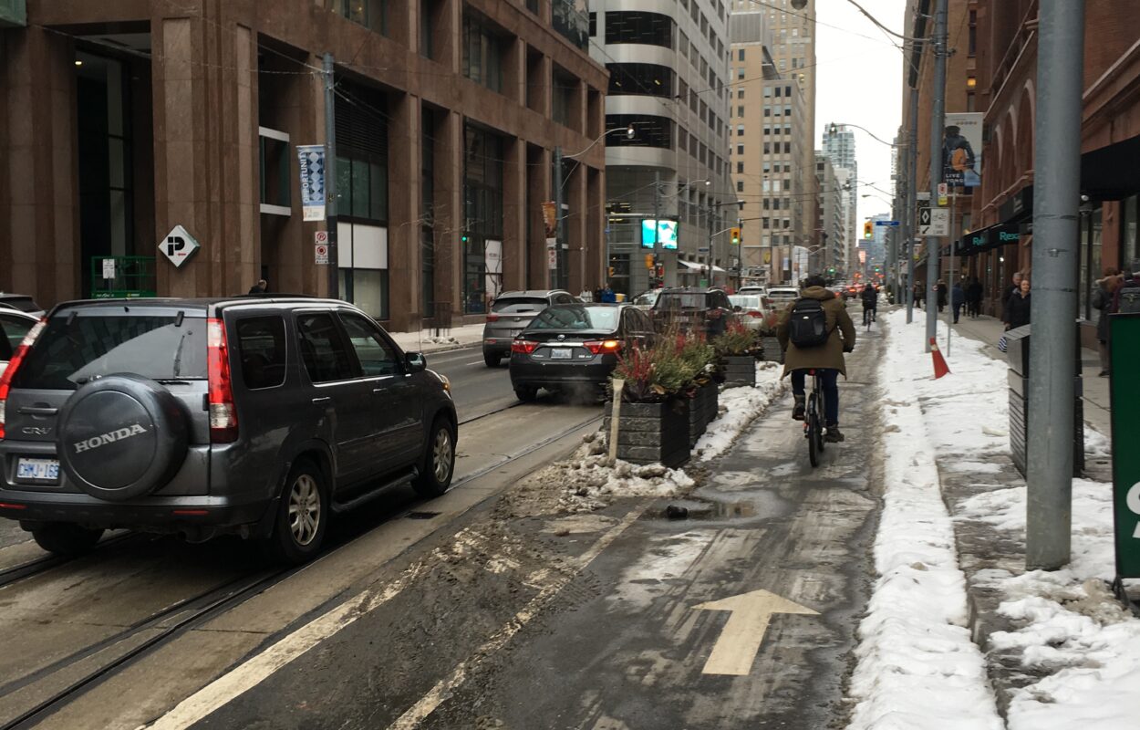 A cyclist biking down the Richmond Street bike lane in the winter